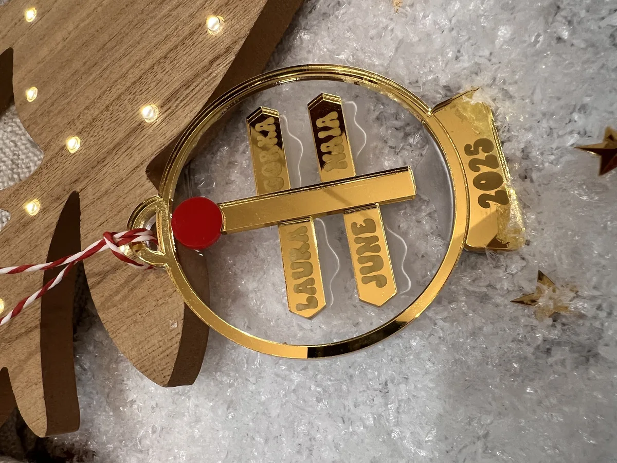 Bola de Navidad familiar personalizada con esquís dorados y nombres de la familia grabados