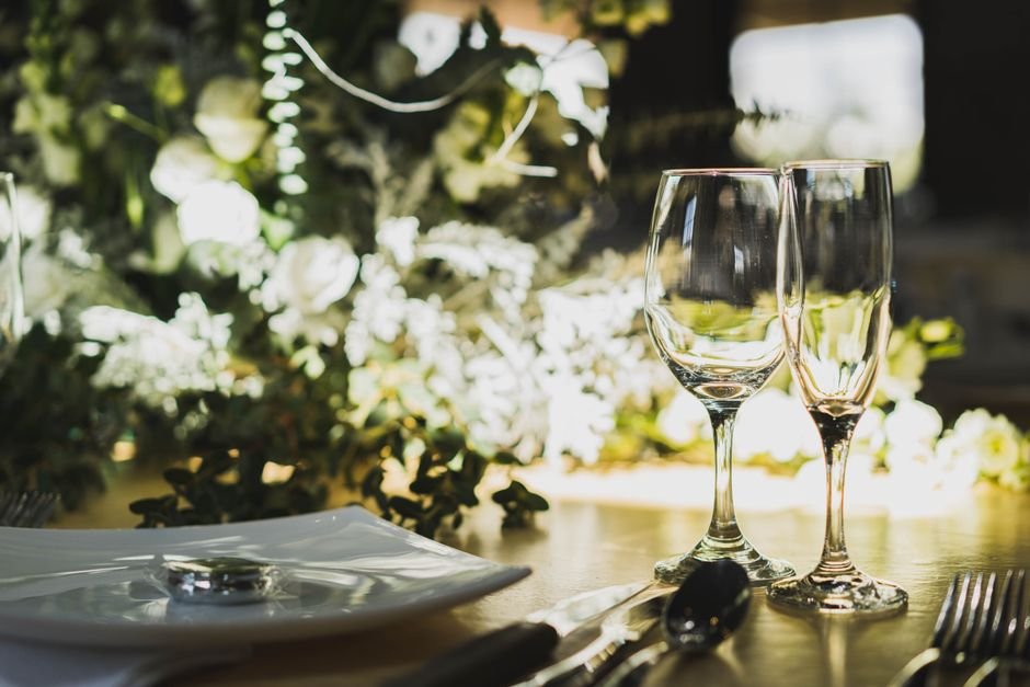 Mesas montadas en el salón de una finca de bodas con decoración y detalles personalizados