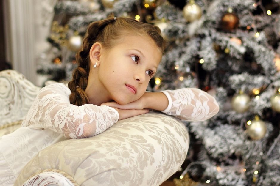 Niño ilusionado mirando el árbol mientras calcula cuánto falta para Papá Noel