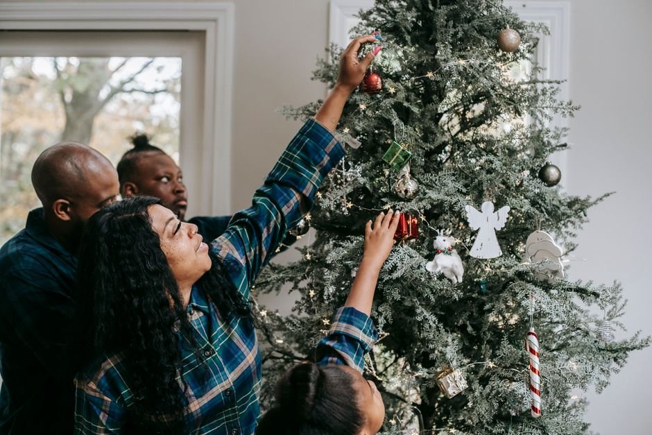 Familia decorando el árbol para hacer más llevadera la espera hasta la noche del 24 de diciembre