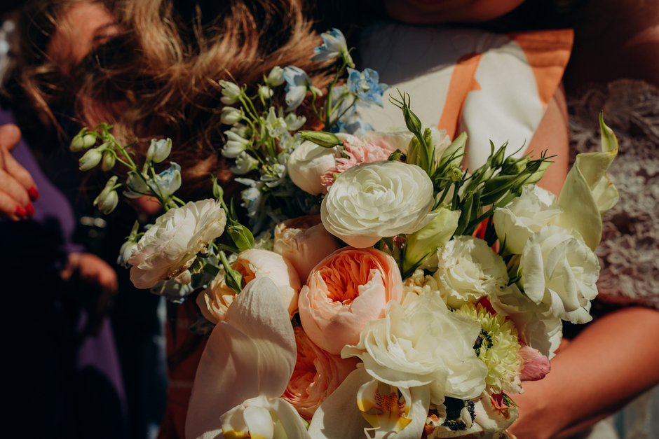 Invitados lanzando confeti de flores a la salida de la ceremonia de boda