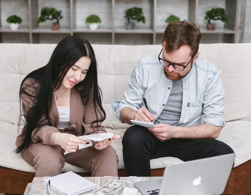 Pareja revisando el presupuesto de su boda y comparando precios de proveedores antes de firmar