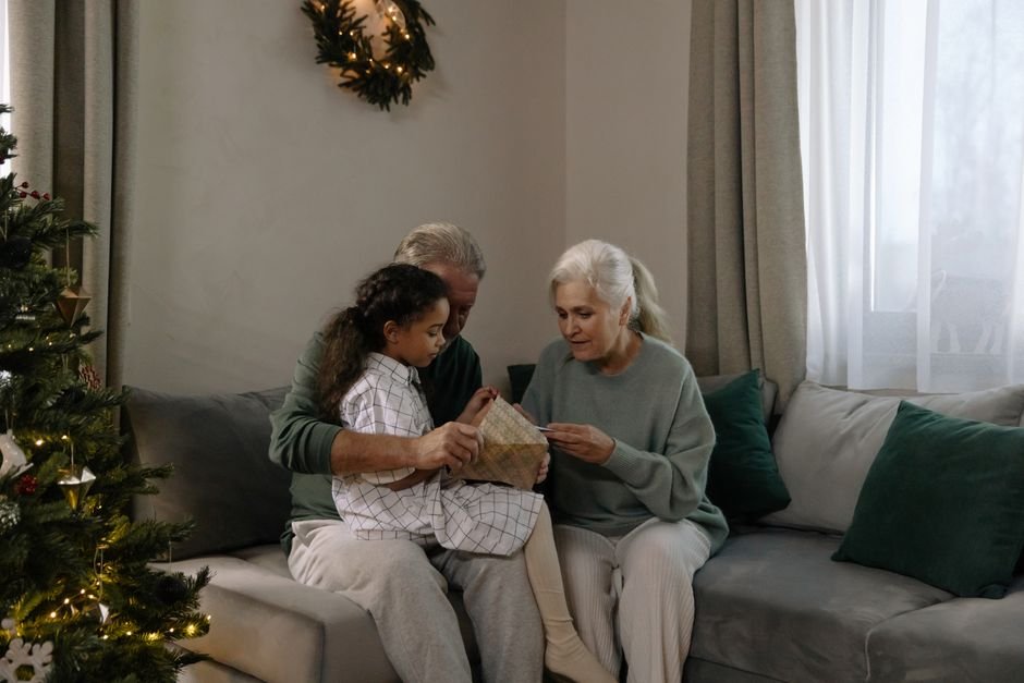 Abuelos abriendo un regalo de Navidad personalizado con los nombres de toda la familia