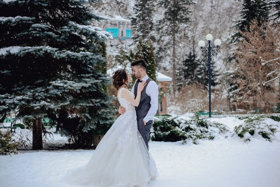 Pareja de novios celebrando su boda fuera de temporada en un paisaje de invierno