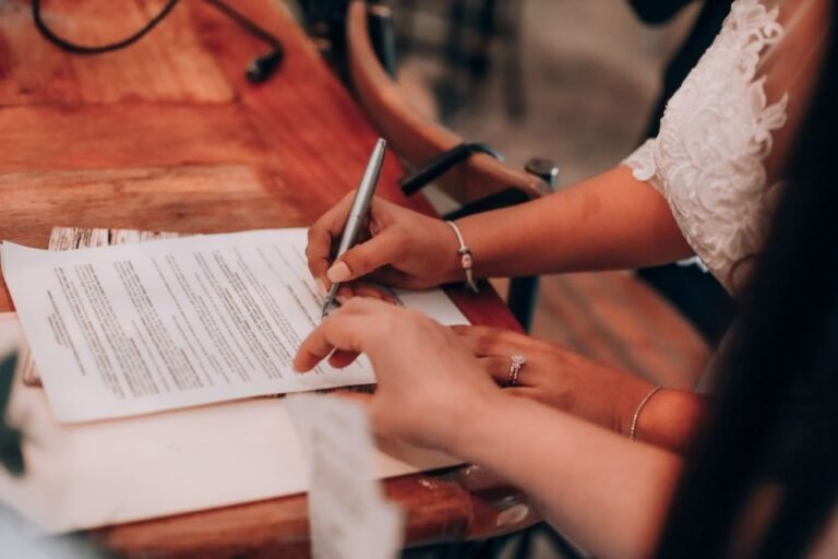 Pareja revisando y firmando el contrato con un proveedor de boda antes de dar la señal