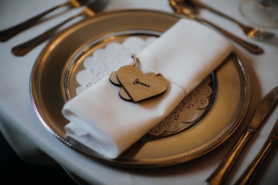 Mesa imperial decorada con marcasitios de madera personalizados para una boda íntima