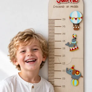 Niño sonriente junto a su medidor de altura infantil de madera personalizado con el nombre Jaime y la frase «Creciendo sin medida», con el globo, la foca y el elefante del circo